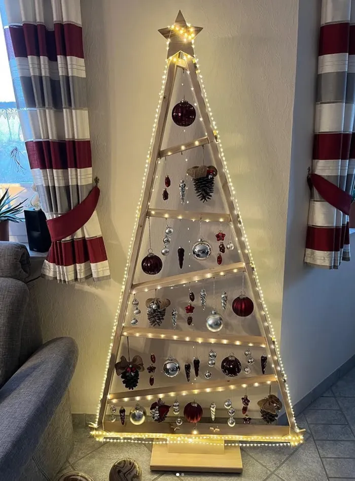 Beleuchtete saisonale Dekoration aus Holz in Weihnachtsbaumform.